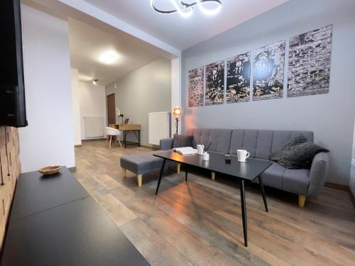 a living room with a couch and a table at Easy Location - Parking - Free Wifi - Tourism and Business in Freyming
