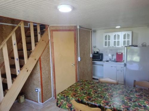 una pequeña cocina con escalera y una habitación con mesa en Departamento Rayen Karu, en Puerto Montt