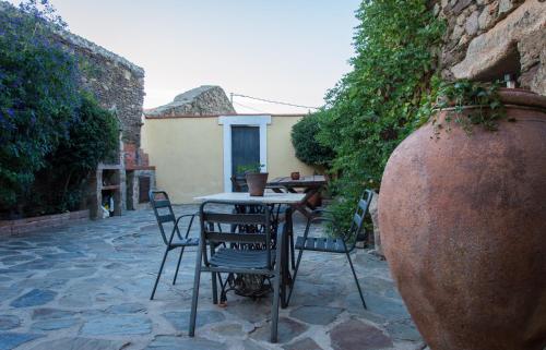 a patio with a table and chairs and a large vase at Casa Rural Villa Vieja in Botija