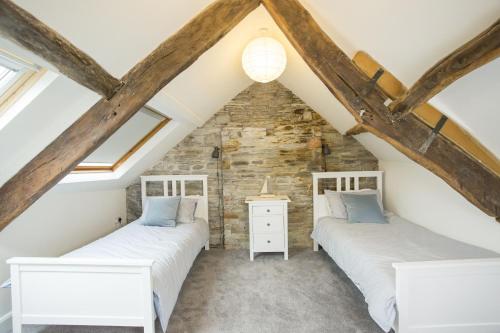 two beds in a attic room with exposed beams at Castle Cottage in Cardigan