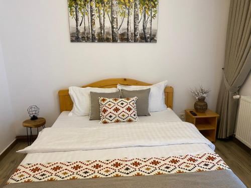 a bedroom with a large white bed with two pillows at Ana Cabana, colt de rai: Aer, Munte, Apa 