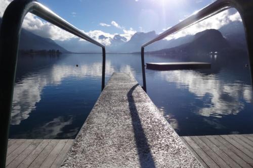 a dock on a lake with mountains in the background at Le pavillon du lac in Duingt