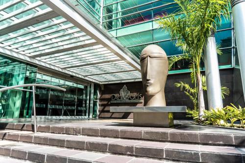 una statua seduta di fronte a un edificio di Decapolis Hotel Panama City a Città di Panama