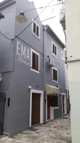 a gray building with a sign on the side of it at APARTMANI EMA in Zadar