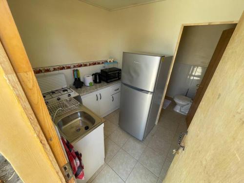 a small kitchen with a refrigerator and a sink at Lindo depto en inmejorable ubicación in Caldera