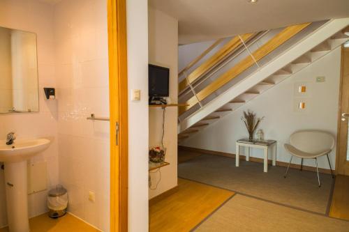 een badkamer met een wastafel en een trap bij casa albergue picota in Mazaricos