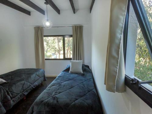1 dormitorio con 2 camas y ventana en Cabaña de mar en Quequén