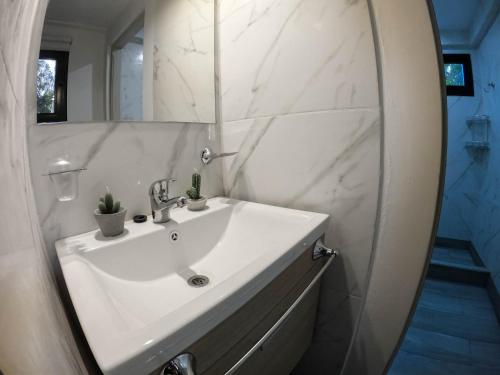 a bathroom with a white sink and a mirror at Cabaña de mar in Quequén