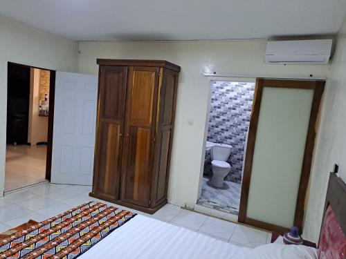 a bedroom with a wooden cabinet and a toilet at Casa Djoko in Dakar