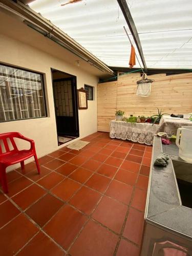 un patio con suelo de baldosa roja y una silla roja en Cabaña Villa Makus, en Paipa