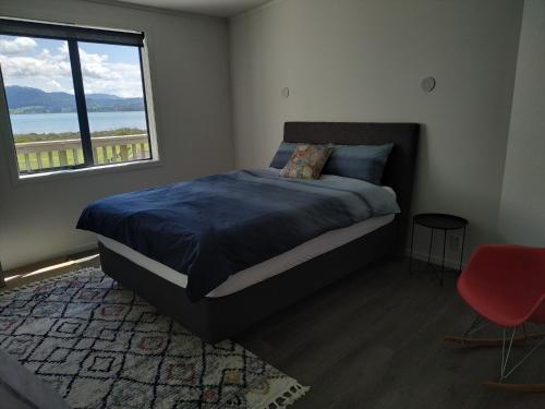 a bedroom with a bed and a large window at The Bowentown in Bowentown