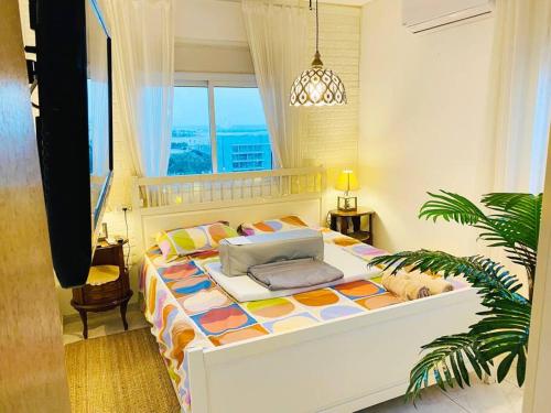 een slaapkamer met een bed in een kamer met een raam bij Piano & Sea view Golden Sea (Sunset view & beach) in Ashdod