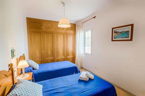 a room with two beds and a table with a lamp at Villa Tuduri in Binibeca