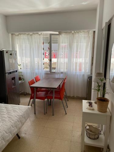 una sala da pranzo con tavolo e sedie rosse di departamento monoambiente a Mar del Plata