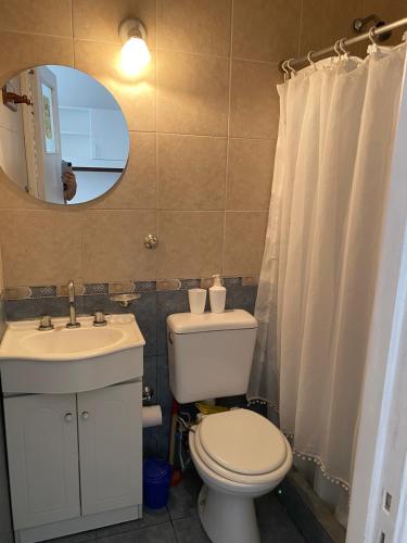 bagno con servizi igienici, lavandino e specchio di departamento monoambiente a Mar del Plata