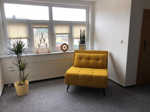 a yellow chair in a room with a window at Am Dürrenbachtal in Klingenthal