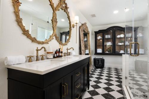 a bathroom with a sink and a mirror at The Plantation House Boutique Inn in Pflugerville