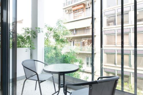a table and chairs on a balcony with a window at Voda Luxury Residence #301 in Athens