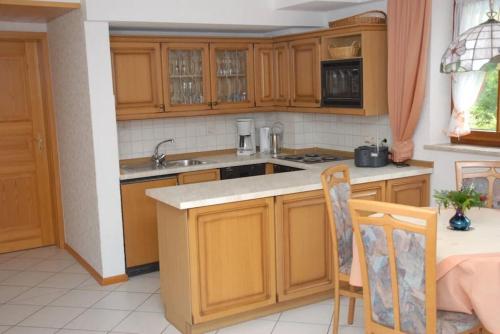 una cocina con armarios de madera y fregadero en Lovingly furnished holiday apartment in our Black Forest house, en Gutach