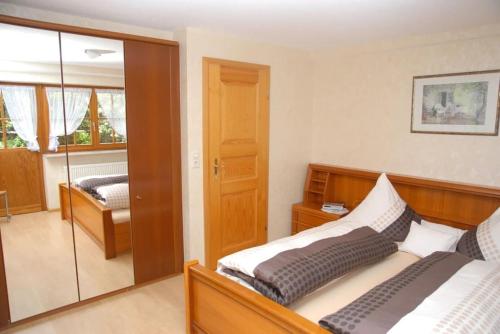 um quarto com 2 camas e uma porta de vidro deslizante em Lovingly furnished holiday apartment in our Black Forest house em Gutach