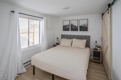 a bedroom with a white bed and a window at Cozy 2 Bedroom Home, Private Backyard with Hot Tub in Seaview