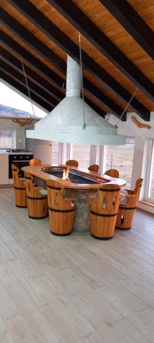 a kitchen with a table with chairs and a light at Apartman OGNJIŠTE in Kupres