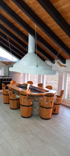 a table and chairs in a room with a ceiling at Apartman OGNJIŠTE in Kupres