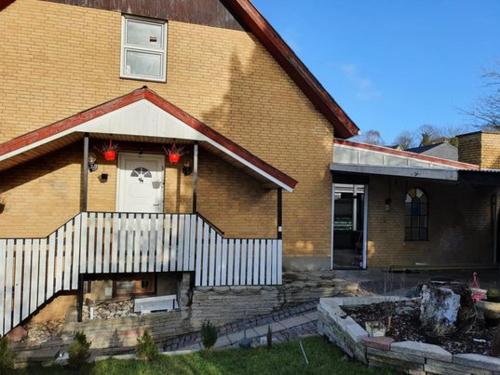 a brick house with a white fence in front of it at Rundvejen Guest House in Aalborg