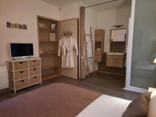 uma sala com um quarto com uma cómoda e um espelho em Le Mas Blanc em Carcassonne
