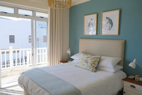 a bedroom with a bed and a large window at Penguin Paradise Apartment Simons Town in Simonʼs Town