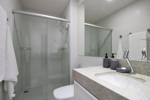 y baño con lavabo y ducha acristalada. en Apartamento com Varanda e Vista Temporada MME, en Maceió