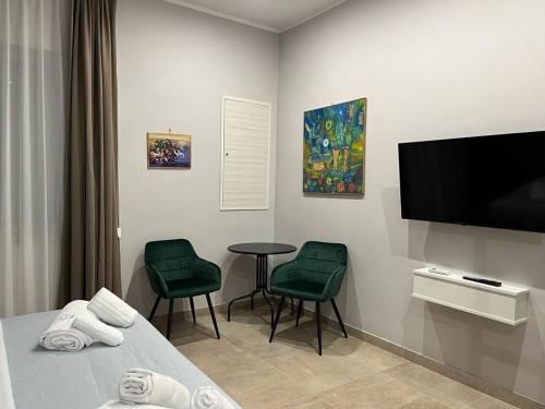 a room with a bed and two chairs and a tv at Avio Suite in Naples