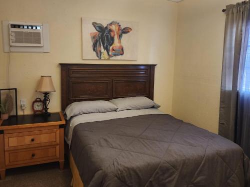 a bedroom with a bed with a cow picture on the wall at Dolan Springs, Grand Canyon Skywalk in Dolan Springs