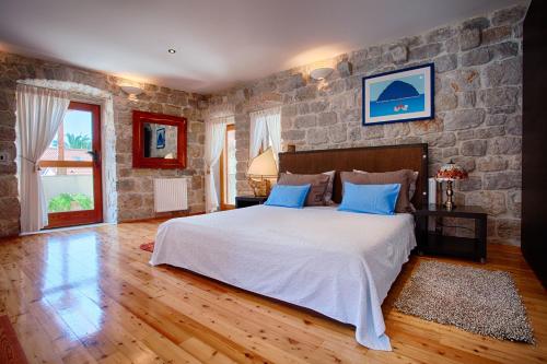 a bedroom with a large bed and a stone wall at Villa Alma Komiza Island Vis in Komiža