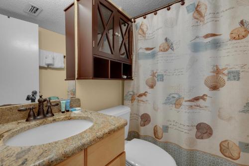 a bathroom with a sink and a shower curtain at Island Echos #2E in Fort Walton Beach