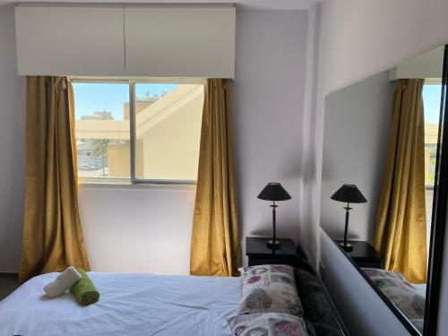 a bedroom with a bed and a large window at private room in a shared flat at best location in Limassol