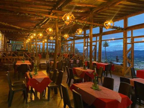 un restaurante con mesas, sillas y luces en MIRADOR DE MARCURA, en Paipa