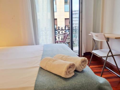 Una habitación de hotel con una cama con toallas. en Pension Yoldi, en San Sebastián