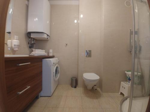 a bathroom with a toilet and a sink and a shower at Aquamarina Międzyzdroje in Międzyzdroje