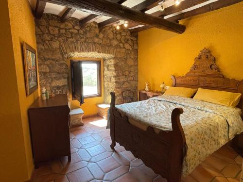Un dormitorio con una cama y una pared de piedra. en Mas Feliu Turismo Rural, en Pujals dels Cavallers
