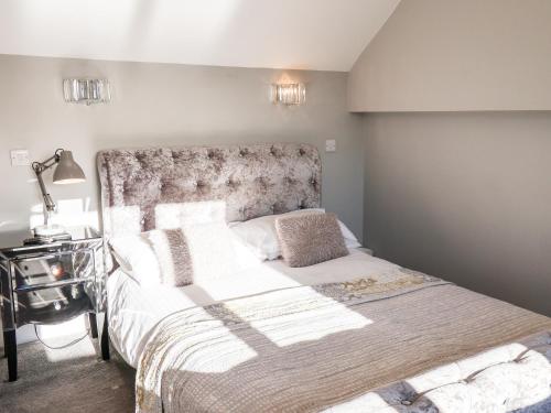 a bedroom with a large bed and a lamp at Tawny Cottage in Scarborough