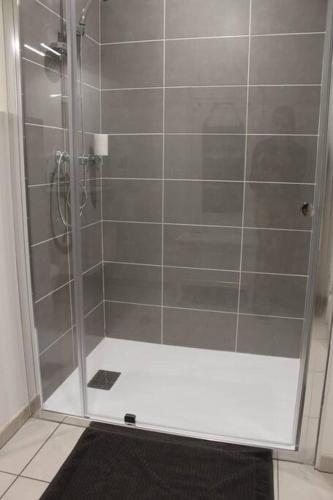 une douche avec une porte vitrée dans une salle de bain dans l'établissement Appt ST VALERY SUR SOMME parking privatif 3/4 pers, à Saint-Valery-sur-Somme