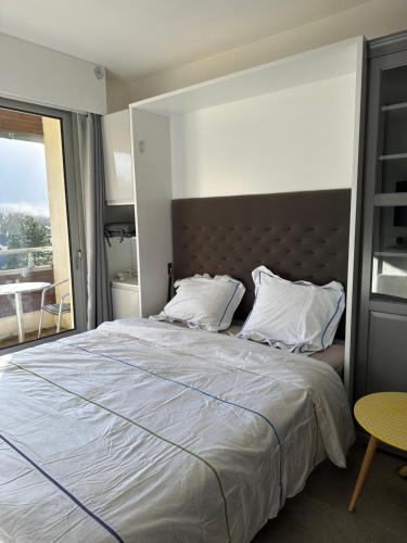 Un dormitorio con una cama grande y una ventana en Studio tout confort, en Bagnoles de l'Orne