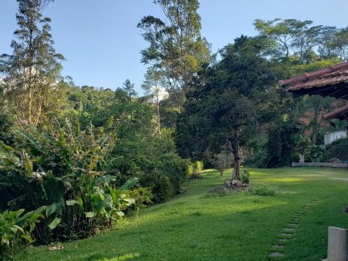 a yard with green grass and trees at Sitio Santa Clara in Teresópolis