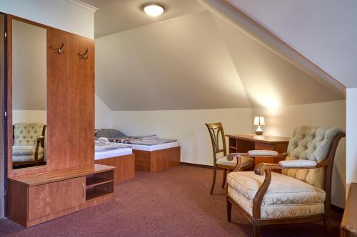 a living room with a chair and a mirror at Motorest Melikana in Humpolec