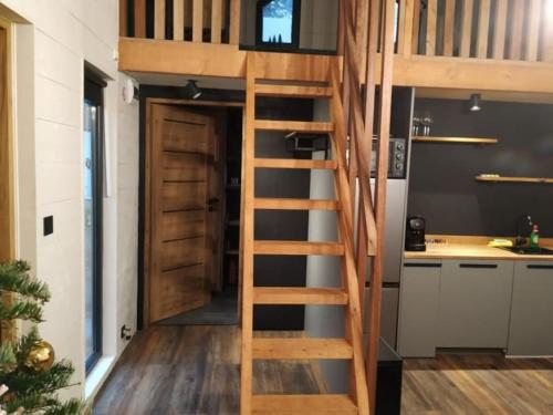 uma escada que leva até uma cama alta numa cozinha em Wooden cave em Diessen