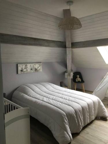 une chambre avec un grand lit blanc dans une pièce dans l'établissement Loft avec jardin, à Corcieux