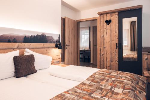 トレーポラッハにあるFerienwohnung Nassfeldのベッドルーム1室(大型ベッド1台、木製ヘッドボード付)