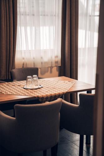 a wooden table with chairs and a table with glasses on it at Ferienwohnung Nassfeld in Tröpolach