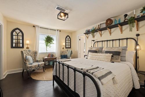 a bedroom with a large bed and a chair at The Plantation House Boutique Inn in Pflugerville